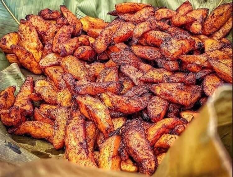 Bananes plantain alloco dorées sur feuille de bananier